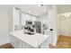 Modern kitchen featuring stainless steel appliances, white cabinets, a breakfast bar, and adjacent laundry room at 9027 Mcdowell Creek Ln, Cornelius, NC 28031