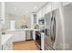 Modern kitchen with stainless steel appliances, white cabinetry, a breakfast bar, and a view to the dining area at 9027 Mcdowell Creek Ln, Cornelius, NC 28031