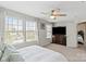 Bedroom features a ceiling fan, bright windows, a dresser with television and adjoining bathroom at 980 Bunker Trce, Rock Hill, SC 29730