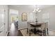 Open dining area with dark wood floors, elegant chandelier, large windows and view to the kitchen at 980 Bunker Trce, Rock Hill, SC 29730