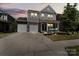 Charming two-story home with stone accents, a well-manicured lawn, and a spacious two-car driveway at dusk at 980 Bunker Trce, Rock Hill, SC 29730