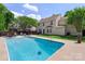 Backyard pool surrounded by a patio area, landscaped yard and a two-story home at 101 Canopy Ct, Mooresville, NC 28115