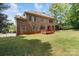 Large backyard featuring a deck, mature trees and partial fence at 10836 Fox Hedge Rd, Matthews, NC 28105