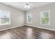 Well-lit bedroom with wood-look floors, neutral walls, a ceiling fan, and multiple windows with great natural lighting at 10836 Fox Hedge Rd, Matthews, NC 28105