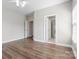 Bright, open bedroom featuring neutral walls, wood-look flooring, and multiple doorways for flexible use of space at 10836 Fox Hedge Rd, Matthews, NC 28105
