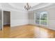 Elegant dining room featuring tray ceilings, decorative chandelier, large windows, and wainscotting on the lower part of walls at 10836 Fox Hedge Rd, Matthews, NC 28105