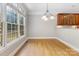 Elegant dining room with hardwood floors, large windows, and stylish lighting fixture at 10836 Fox Hedge Rd, Matthews, NC 28105