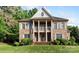 Stately brick home featuring a columned porch and landscaped front yard at 10836 Fox Hedge Rd, Matthews, NC 28105