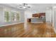 Open living room with hardwood floors, large windows and modern kitchen featuring stainless steel appliances and beautiful cabinetry at 10836 Fox Hedge Rd, Matthews, NC 28105