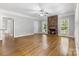 Spacious living room with hardwood floors, ceiling fan, brick fireplace and large windows at 10836 Fox Hedge Rd, Matthews, NC 28105