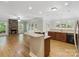 Open concept layout with kitchen island, stone fireplace, and lots of natural light at 10836 Fox Hedge Rd, Matthews, NC 28105