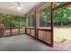 Screened-in porch with ceiling fan, concrete floor, wood trim, and view to wooded backyard at 10836 Fox Hedge Rd, Matthews, NC 28105