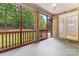 Screened-in porch with ceiling fan, concrete floor, wood trim, brick columns and access to backyard deck at 10836 Fox Hedge Rd, Matthews, NC 28105