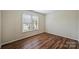 A bright room with wood floors features a window with white blinds at 10943 Winterbourne Ct, Charlotte, NC 28277