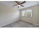 A vacant bedroom with carpet and fan features a double window at 10943 Winterbourne Ct, Charlotte, NC 28277