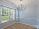 Cozy dining area with natural light, modern chandelier, and neutral wall color at 10943 Winterbourne Ct, Charlotte, NC 28277