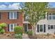 Charming brick townhome featuring a landscaped front yard and a welcoming entrance at 10943 Winterbourne Ct, Charlotte, NC 28277