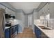 Galley kitchen featuring white countertops, stainless steel appliances, and blue lower cabinets at 10943 Winterbourne Ct, Charlotte, NC 28277