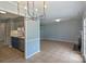 Open-concept living space showcasing kitchen and dining area with modern lighting and tile floors at 10943 Winterbourne Ct, Charlotte, NC 28277