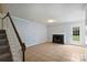 Spacious living room with a fireplace and staircase, featuring tile flooring and neutral walls at 10943 Winterbourne Ct, Charlotte, NC 28277