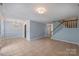Bright and airy living space with tiled flooring, modern lighting, and staircase access at 10943 Winterbourne Ct, Charlotte, NC 28277
