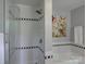 Bathroom featuring black and white tile in the shower and separate tub with colorful wall art at 1114 Palmyra Dr, Tega Cay, SC 29708