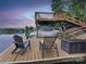A waterfront dock area features a boat lift, seating, and picturesque lake views at sunset at 1114 Palmyra Dr, Tega Cay, SC 29708