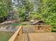 Sunny dock overlooking lake, views of the house, trees and boat house at 1114 Palmyra Dr, Tega Cay, SC 29708