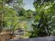 Beautiful lake view with dock and patio area, as seen through lush green foliage at 1114 Palmyra Dr, Tega Cay, SC 29708
