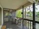 Covered porch showcasing a small wood table, chairs, and pretty views of the backyard and lake at 1114 Palmyra Dr, Tega Cay, SC 29708