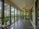Screened-in porch with wood flooring, ceiling fan, and beautiful lake views from many large windows at 1114 Palmyra Dr, Tega Cay, SC 29708