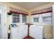 Cozy laundry room featuring white cabinets, tile floors, washer, dryer, and a window with valance at 1115 Old Thompson Ave, Lancaster, SC 29720
