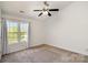 This bedroom features neutral carpet, a ceiling fan, and a window offering natural light at 11229 Lions Mane St, Charlotte, NC 28273