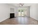 Bright living room featuring wood floors, a fireplace, and french doors leading to the outside at 11229 Lions Mane St, Charlotte, NC 28273