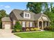 Charming home showcasing manicured lawn, stone accents, an American flag, and inviting curb appeal at 11424 Brangus Ln, Mint Hill, NC 28227
