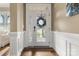 Bright foyer with hardwood floors, decorative wainscoting, and glass paneled front door at 11424 Brangus Ln, Mint Hill, NC 28227