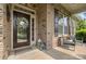 Inviting front porch featuring brick accents, decorative wreath, lanterns, and comfortable seating at 11424 Brangus Ln, Mint Hill, NC 28227