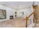 Bright living room with a fireplace and staircase showcasing the home's potential for cozy Gathering living at 12016 Gemstone Ct, Charlotte, NC 28269
