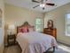 Cozy bedroom with neutral walls, plush pink bedding, and a window providing natural light at 1222 Kings Bottom Dr, Fort Mill, SC 29715