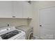 Well-equipped laundry room with modern washer and dryer, along with ample cabinet space at 1222 Kings Bottom Dr, Fort Mill, SC 29715