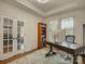 Well-lit office with large desk, shelving, area rug, and french doors to the home interior at 1222 Kings Bottom Dr, Fort Mill, SC 29715