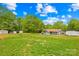 Expansive backyard with multiple storage sheds, lawn, and wooded perimeter at 1279 Rocky Creek Rd, Shelby, NC 28152