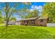 Charming single-story home with beautiful green lawn, shade tree, and neutral exterior with a welcoming front porch at 1279 Rocky Creek Rd, Shelby, NC 28152