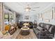 Comfortable living room featuring a large ceiling fan, modern decor, stylish furniture, and sun-filled windows at 1279 Rocky Creek Rd, Shelby, NC 28152