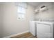Modern laundry room with side-by-side white washer and dryer and wire rack shelving at 129 Millstream Dr, China Grove, NC 28023
