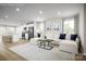 Open-concept living room features natural light, modern furnishings, and seamless flow to the kitchen at 129 Millstream Dr, China Grove, NC 28023