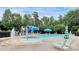 Community pool area featuring splash pad, fountain, lounge chairs, and shade umbrellas all surrounded by lush trees at 13402 David Jennings Ave, Charlotte, NC 28213