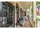 Cozy covered porch with wicker seating, floral cushions, brick flooring, and ample space for relaxing at 172 Harper Lee St, Davidson, NC 28036