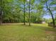 Expansive backyard featuring mature trees, green grass, and a shed providing ample outdoor space and storage at 1758 Bridlewood Ct, Gastonia, NC 28054