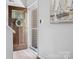 Inviting home foyer with a decorative wreath, storm door and wood-look flooring at 1758 Bridlewood Ct, Gastonia, NC 28054